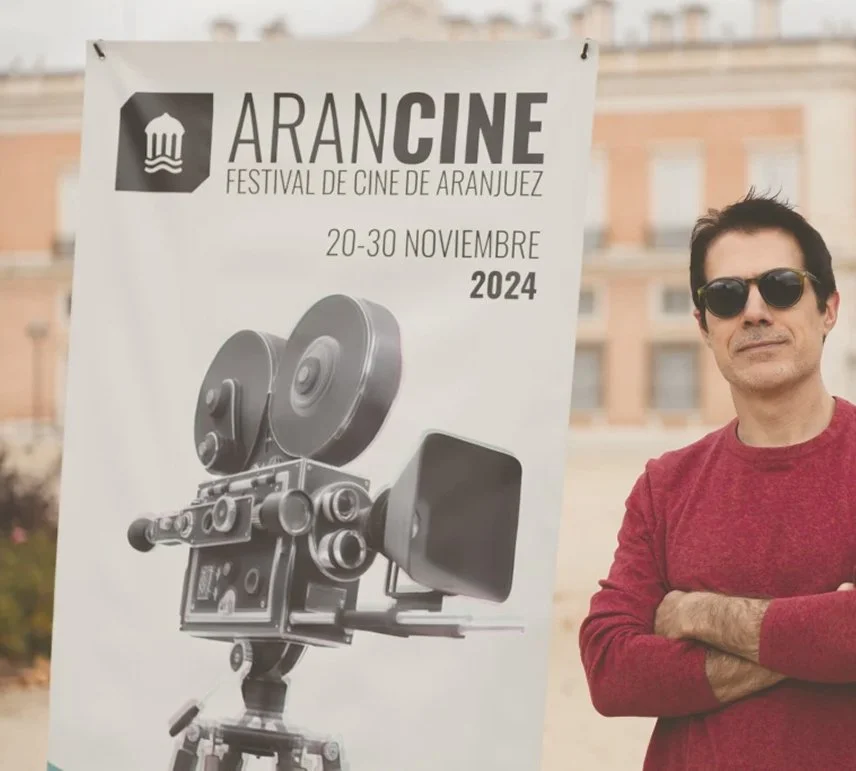 Asistente junto al cartel del festival